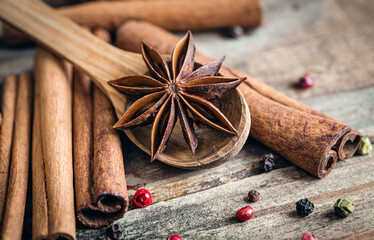 Composition with star anise and cinnamon sticks on a wooden background.