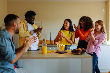 Joyful friends having birthday party at home.