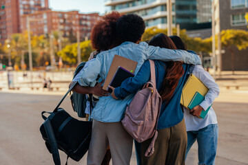 Students in group hug outdoors.