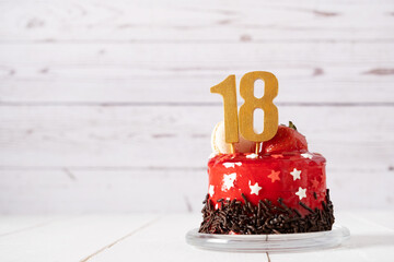 The number Eighteen on a red birthday cake on a light background