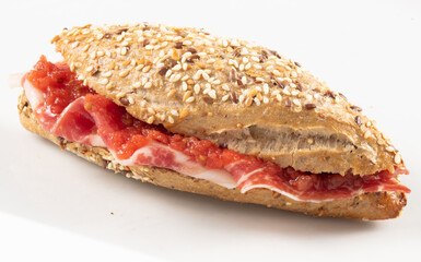 Baguette con semillas de jamón ibérico sobre fondo blanco. Iberian ham baguette with seeds on white background.