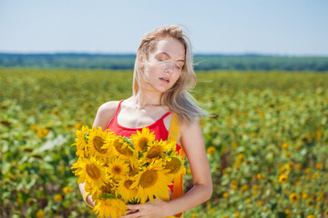 Naklejka na ściany i meble Young beautiful girl with a bouquet of sunflowers