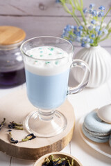 Obraz na płótnie Canvas Thai blue Anchan tea with whipped vegetable milk in a clear glass. A healthy drink for detox and diet