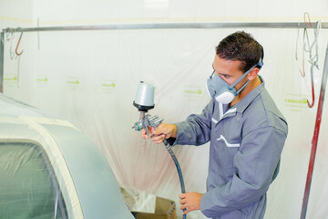 Mechanic spray painting a car