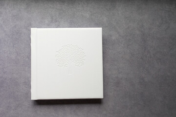 Photo book with leather cover. Stylish white wedding or family photo album. Beautiful notepad or photobook with elegant embossing. Printing products. Individual products. Details