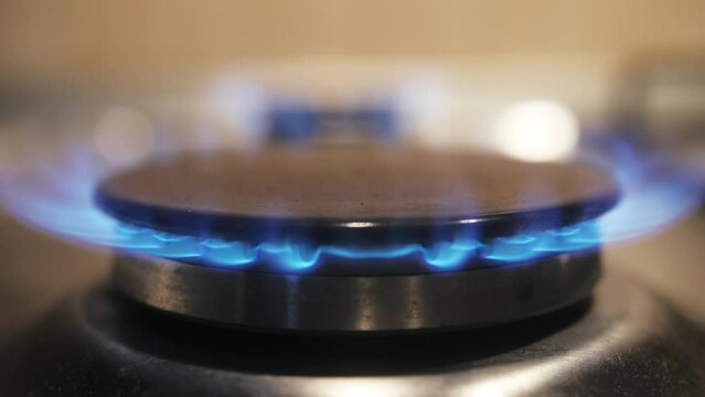 Natural Gas burning in the kitchen. High gas bill problems. Gas burner turning on the kitchen oven.