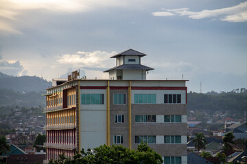 The building is in the middle of a residential area with evening clouds in the background