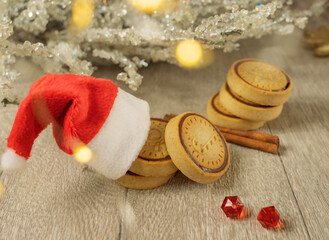 Santa Claus hat, Christmas cookies and flickering lights - bokeh. Family holiday - Christmas.