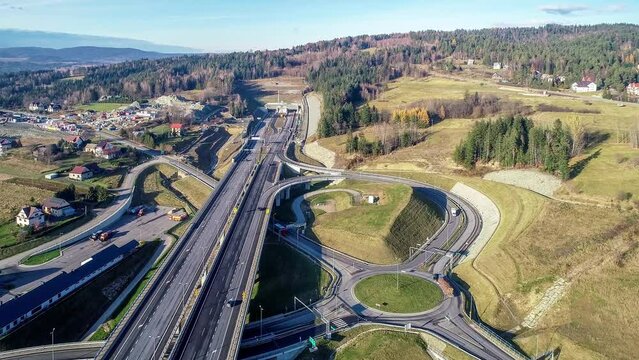 Poland. Zakopianka highway with newly opened tunnel in November 2022.  Multilevel spaghetti junction with traffic circles, viaducts, slip roads and traffic near Skomielna Biała. Aerial approach video
