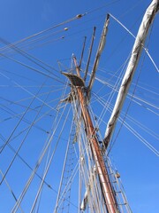 Fototapeta premium Mast of an old sailing ship with a folded sail and ropes