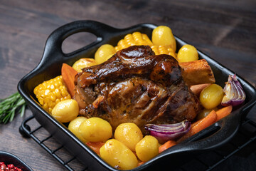 Pork shank knuckle with baked potatoes and corn