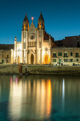 Fototapeta na wymiar Neo-Gothic church of Our Lady of Mount Carmel (Balluta parish church) at night, Balluta bay, Malta