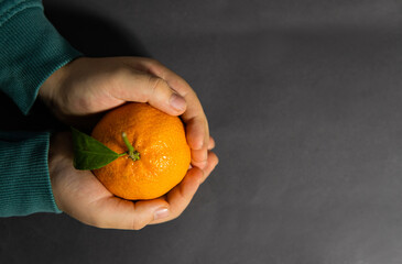 an orange in the hands of a child
