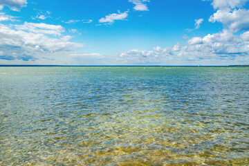 Transparent lake water and scenic blue sky clouds on the horizon