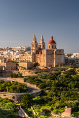 Fototapeta na wymiar Il-Mellieha, Malta - Mellieha town at sunny day with Paris Church on hill top