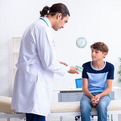 Fototapeta na wymiar Young male doctor examining boy in the clinic