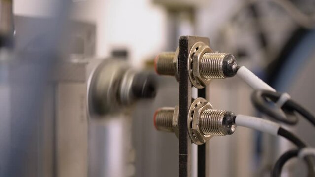 Closeup of laser sensor of a factory machine. Automated assembly line.