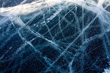 Ice on a frozen river in winter. Ice texture. Dark blue ice with white cracks. With copy space.