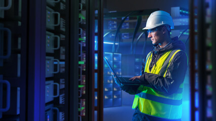 Man with laptop in server room. System administrator for industrial companies. Guy with computer....