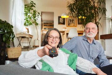 Senioren Paar als Zuschauer mit TV Fernbedienung