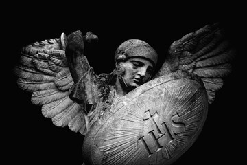 Saint Michael struggles with evil. Fragment of antique statue against black background. Good triumphs over evil concept. - obrazy, fototapety, plakaty