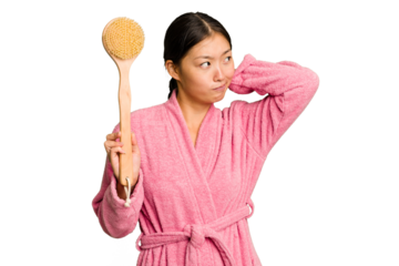 Young asian woman holding a shower brush isolated touching back of head, thinking and making a choice.