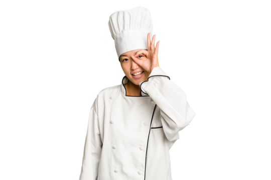 Young asian cook woman isolated excited keeping ok gesture on eye.