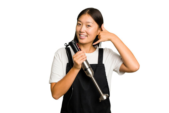 Young asian cook woman holding a blender isolated showing a mobile phone call gesture with fingers.