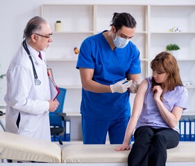 Obraz premium Two doctors examining young woman