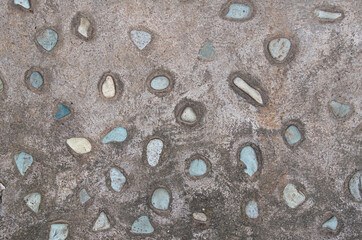 Small stones pressed into concrete pavement background and wallpaper texture
