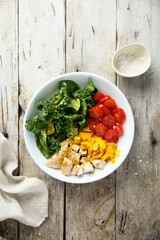 Homemade chicken bowl with mango and kale