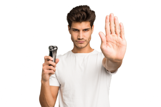 Young caucasian man holding a razor isolated standing with outstretched hand showing stop sign, preventing you.