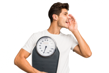 Young caucasian man holding a scale isolated shouting and holding palm near opened mouth.