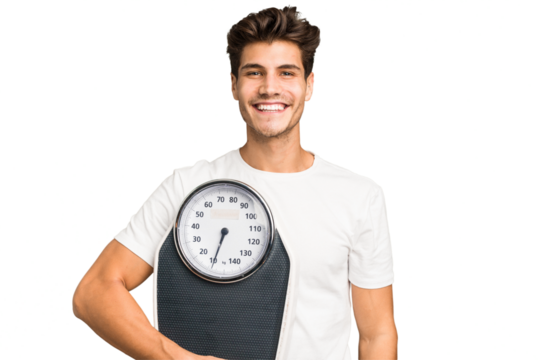 Young caucasian man holding a scale isolated happy, smiling and cheerful.