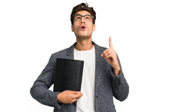Young teacher caucasian man holding a book isolated pointing upside with opened mouth.
