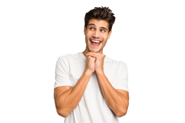 Young caucasian handsome man isolated keeps hands under chin, is looking happily aside.