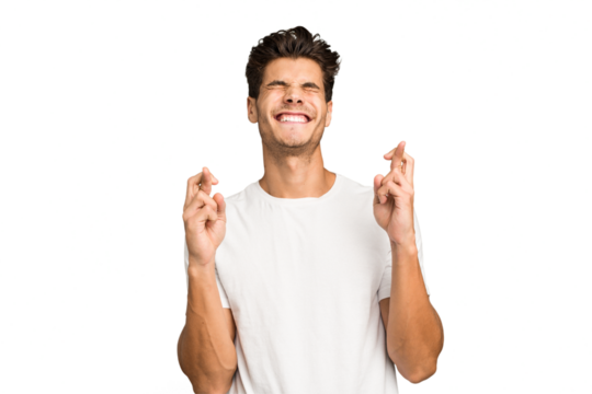 Young caucasian handsome man isolated crossing fingers for having luck