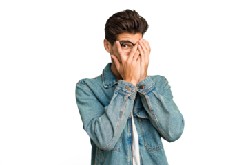 Young caucasian handsome man isolated blink at the camera through fingers, embarrassed covering face.