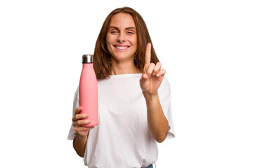 Young caucasian woman holding a pink thermo isolated showing number one with finger.