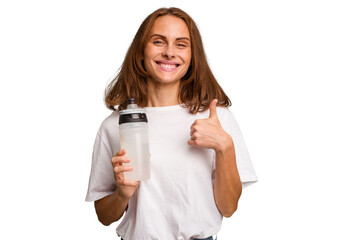 Young caucasian sport woman holding a bottle of water isolated smiling and raising thumb up