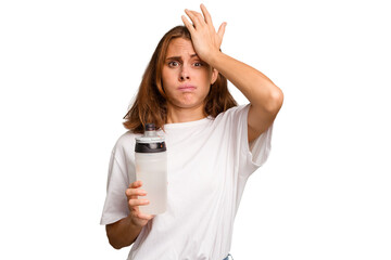 Young caucasian sport woman holding a bottle of water isolated being shocked, she has remembered...