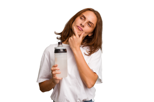 Young caucasian sport woman holding a bottle of water isolated looking sideways with doubtful and skeptical expression.