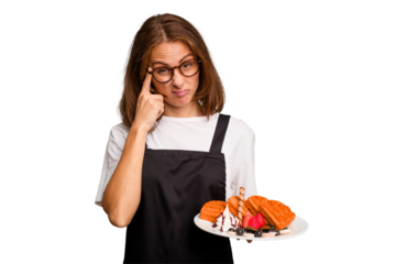 Young caucasian woman holding a waffles dish isolated pointing temple with finger, thinking, focused on a task.