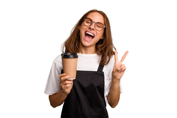 Young caucasian woman holding takeaway coffee isolated joyful and carefree showing a peace symbol...