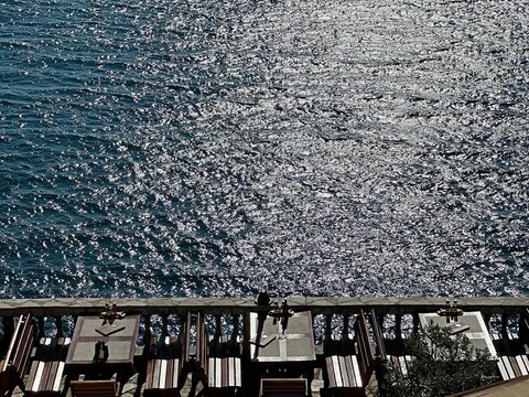 Restaurant on the beach by the sparkling sea water on  summer evening.