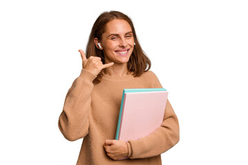 Fototapeta premium Young student woman holding a books isolated showing a mobile phone call gesture with fingers.