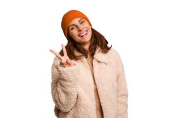 Young caucasian woman wearing winter clothes isolated joyful and carefree showing a peace symbol with fingers.