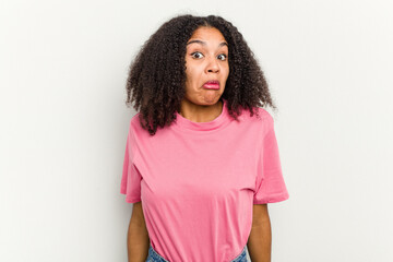 Young african american woman isolated on white background shrugs shoulders and open eyes confused.