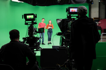 Lights.. Camera.. Action! Woman and Man anchor reporting news in studio. Film and Tv industry.