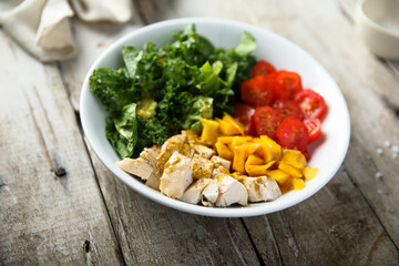 Homemade chicken bowl with mango and kale